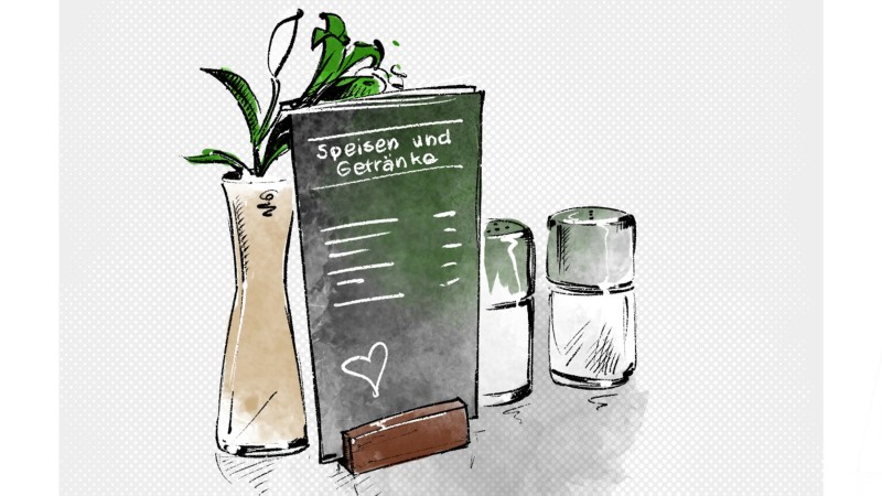 Eine Karte für Speisen und Getränke steht in einer Halterung. Links neben der Karte steht eine Vase mit einer Pflanze darin und rechts neben der Karte stehen zwei Gewürzstreuer.