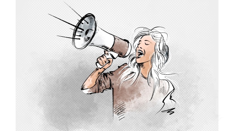 Eine Frau spricht durch ein Megafon.